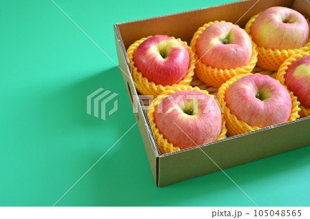 beautiful pink apple in the box on green background, healthy fruit beautiful pink apple in the box on green background, healthy fruit 105048565