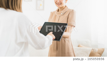 エステサロン・ネイルサロンでお客様にメニューの説明をする女性(タブレットPC) エステサロン・ネイルサロンでお客様にメニューの説明をする女性(タブレットPC) 105050936