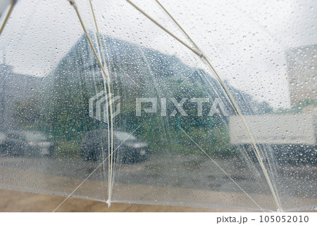 雨粒がついたビニール傘、未舗装の寂れた工場街を歩く 105052010