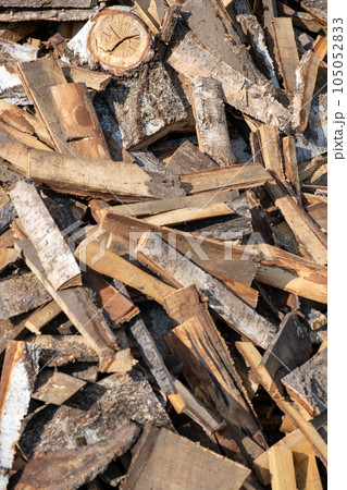 A large pile of different sawn firewood for the stove. Preparing firewood for the winter. Firewood background. A large pile of different sawn firewood for the stove. Preparing firewood for the winter. Firewood background. 105052833