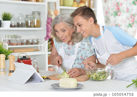 family making fresh salad in kitchen at the table  105054758
