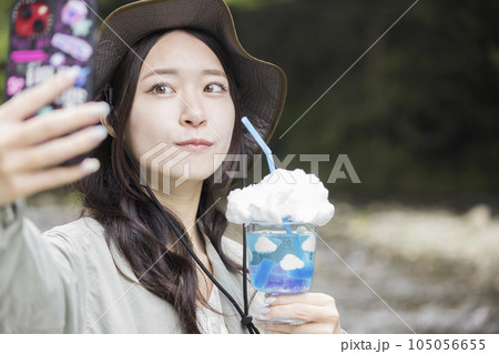 アウトドアで映えドリンクを作って自撮りする若い女性　青空ソーダ 105056655