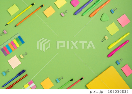Frame of colorful school and office stationery set on green background. Flatly. 105056835