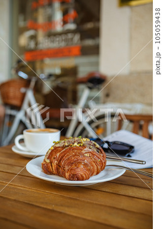 Morning coffee and croissant with reading material Morning coffee and croissant with reading material 105059438