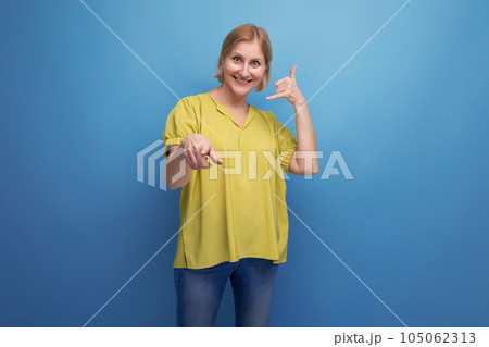 middle-aged blond woman in casual dress waving her arms 105062313