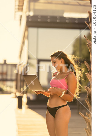 beautiful girl in bikini with laptop on the beach 105064128