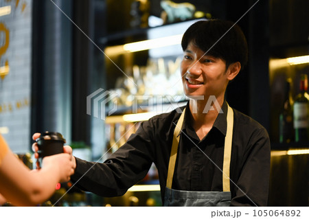 Friendly asian man barista wearing apron serving coffee to customer. Start up, small business owner, food and drink concept 105064892