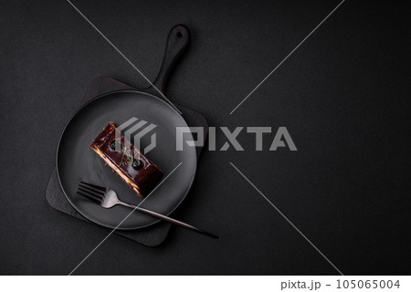Delicious sweet dessert cheesecake with candied fruits in chocolate 105065004