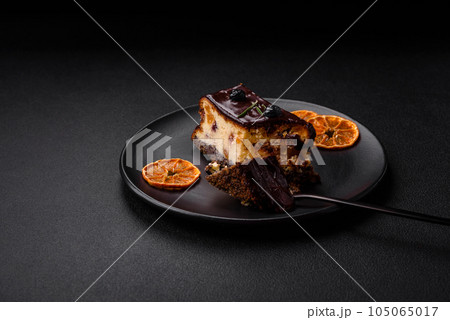 Delicious sweet dessert cheesecake with candied fruits in chocolate Delicious sweet dessert cheesecake with candied fruits in chocolate 105065017