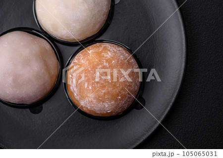 Delicious sweet mochi dessert with toppings on a dark concrete background 105065031