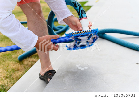 Man assembles a swimming pool vacuum cleaner. Man assembles a swimming pool vacuum cleaner. 105065731