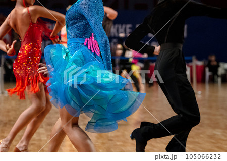 female dancers in red and blue dress and man in black dress, dancesport competition, latino dance 105066232