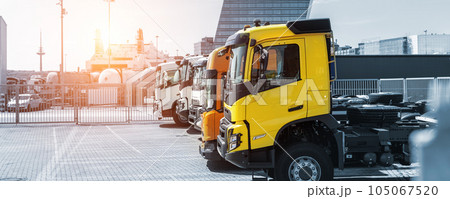 Side view many new heavy commercial cargo transport vehicles stand at port for export import shipping in Germany. Modern semi-trailer business industry truck tractor chassis sale sea logistics 105067520