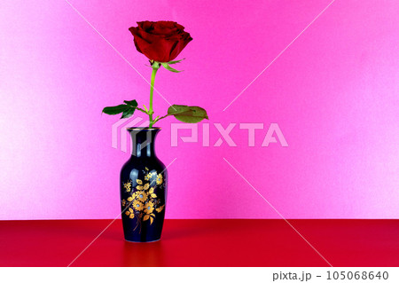 Blue Decorated Flower Vase with Red Rose on a Red Surface and Pink Background 105068640
