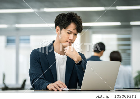 ノートパソコンの画面を見ながら考え込む30代のビジネスマン 105069381