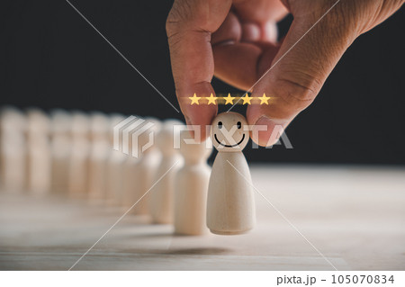 Man hand clutches wooden human figure. HR officer seeks leader and CEO. Leader steps out of the crowd. Personal development, motivation, challenge. HR, HRM, HRD concepts. Man hand clutches wooden human figure. HR officer seeks leader and CEO. Leader steps out of the crowd. Personal development, motivation, challenge. HR, HRM, HRD concepts. 105070834