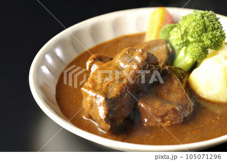 ブロッコリー、人参、ジャガイモが付け合わせてある厚切り牛タンの熱々ビーフシチューを黒背景で撮影 ブロッコリー、人参、ジャガイモが付け合わせてある厚切り牛タンの熱々ビーフシチューを黒背景で撮影 105071296
