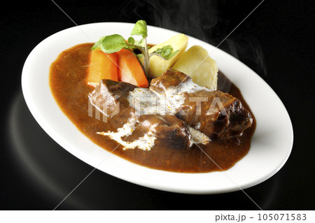 クレソン、人参、ジャガイモの付け合わせと生クリームがけ厚切り牛タンの熱々ビーフシチューを黒背景で撮影 105071583