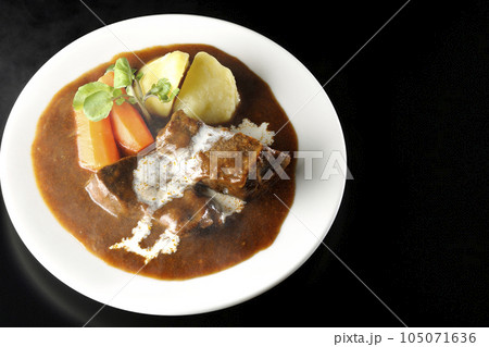 クレソン、人参、ジャガイモと生クリームがけ厚切り牛タンの熱々ビーフシチューを黒背景で俯瞰撮影 105071636