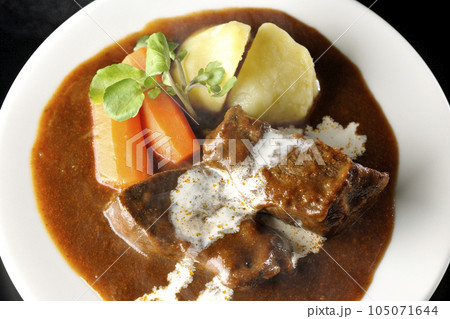 クレソン、人参、ジャガイモと生クリームがけ厚切り牛タンの熱々ビーフシチューを黒背景で俯瞰撮影 105071644
