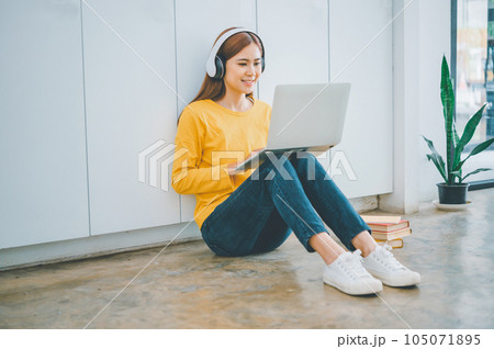 young student wearing headphones studies online, distance learning, and keeps up to date on the global coronavirus pandemic. 105071895
