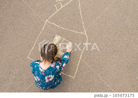 Junior school girl draws windows and curtains of house 105073175