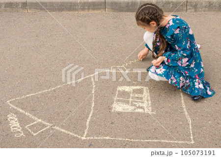 Junior school girl draws windows and curtains of house 105073191