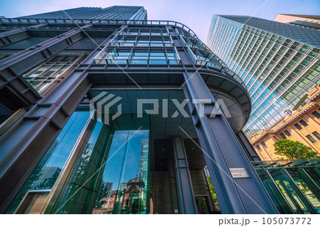 日本の東京都市景観 7月。猛暑…東京・丸の内のオフィス街や新丸ビルのガラス窓に映る東京駅などを望む 105073772