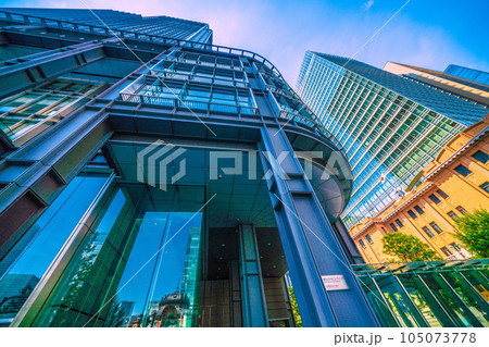 日本の東京都市景観 7月。猛暑…東京・丸の内のオフィス街や新丸ビルのガラス窓に映る東京駅などを望む 105073778