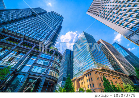 日本の東京都市景観 7月。猛暑…東京・丸の内のオフィス街や新丸ビルのガラス窓に映る東京駅などを望む 105073779