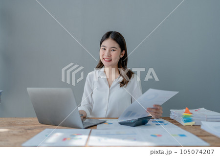 Young asian female work with financial papers at home count on calculator before paying taxes receipts online, planning budget glad to find chance for economy saving money, audit concepts. Young asian female work with financial papers at home count on calculator before paying taxes receipts online, planning budget glad to find chance for economy saving money, audit concepts. 105074207