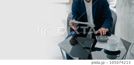 businessman or accountant working on calculator and laptop computer to calculate business data during using accountancy document at office businessman or accountant working on calculator and laptop computer to calculate business data during using accountancy document at office 105074213