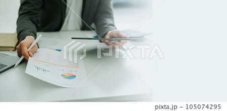 businessman or accountant working on calculator and laptop computer to calculate business data during using accountancy document at office businessman or accountant working on calculator and laptop computer to calculate business data during using accountancy document at office 105074295