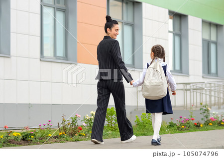 Mother and daughter going to primary school together Mother and daughter going to primary school together 105074796