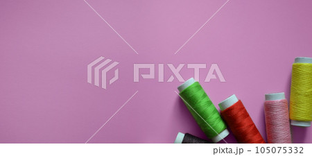 spools of thread on a pink background, a banner for an atelier, tailoring, a photo for a sewing workshop, sewing threads, a place for text spools of thread on a pink background, a banner for an atelier, tailoring, a photo for a sewing workshop, sewing threads, a place for text 105075332