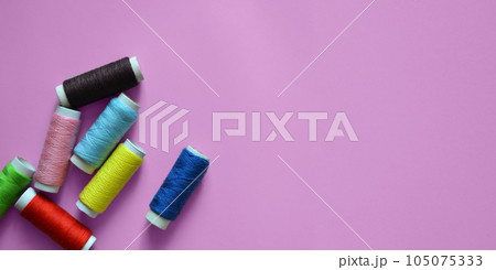 spools of thread on a pink background, photos for a sewing workshop, tailoring, a banner for an atelier, sewing threads, a place for text spools of thread on a pink background, photos for a sewing workshop, tailoring, a banner for an atelier, sewing threads, a place for text 105075333