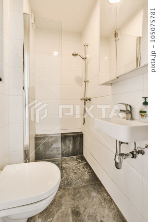 a bathroom with a sink, toilet and shower head mounted on the wall in it's corner to the left a bathroom with a sink, toilet and shower head mounted on the wall in it's corner to the left 105075781