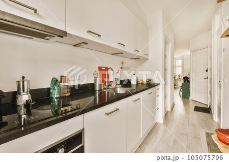 a kitchen area with white cabinets and black counter tops on the counters in this room is very clean, but it's not 105075796