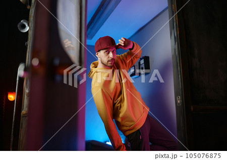 Fashion b-boy breakdancer standing in frozen move in doorway of subway train 105076875