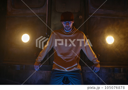 Portrait of breakdancer preparing for performance standing in smoke Portrait of breakdancer preparing for performance standing in smoke 105076878