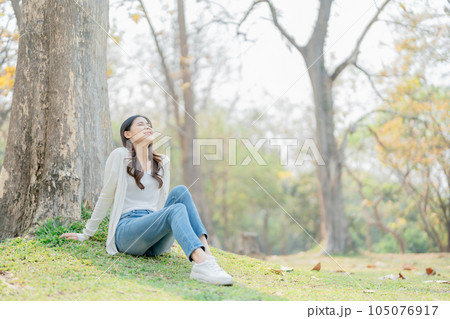 relax concepts, Pretty Asian teenage girl expressing relax, resting, stretch under tree in public park. relaxing relax concepts, Pretty Asian teenage girl expressing relax, resting, stretch under tree in public park. relaxing 105076917