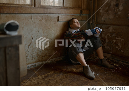 Selective focus of hopeless woman beggar sleeping in corner of room 105077051