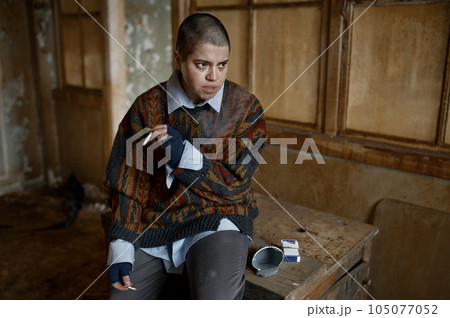 Punk female beggar suffering from nicotine and drug addiction 105077052