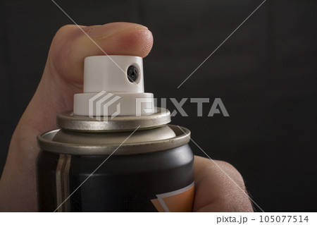 Close-up view of human hand and spray bottle isolated on black Close-up view of human hand and spray bottle isolated on black 105077514