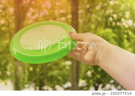 hand throwing a frisbee disc in the park on a summer day 105077554