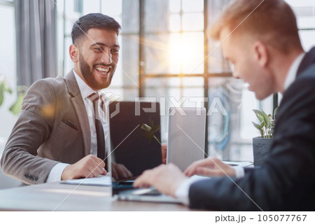 Two happy men working together on a new business project Two happy men working together on a new business project 105077767