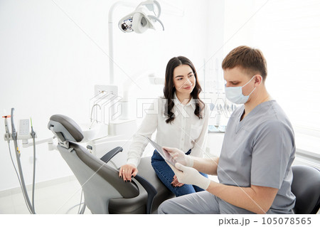Male dentist with digital tablet. Modern treatment in professional dental clinic. Male dentist with digital tablet. Modern treatment in professional dental clinic. 105078565