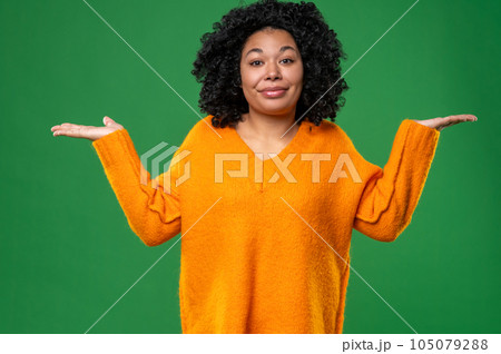 Curly-haired young woman in orange on a green background 105079288