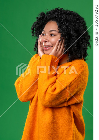 Happy dark-haired ypung woman in orange Happy dark-haired ypung woman in orange 105079291