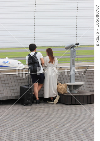 羽田空港の展望デッキ　展望デッキで離陸する飛行機を眺める利用客 105080767